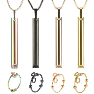 Detail of mindfulness necklaces and rings set in rainbow, black, rose gold and gold finishes