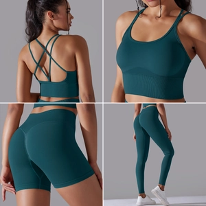 Three-piece seamless dark teal yoga set featuring cross-back bra, high-waist shorts, and leggings