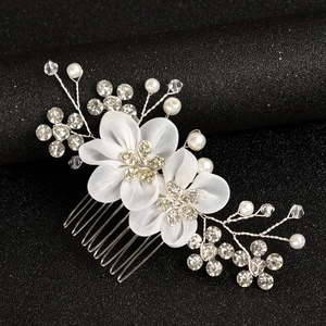 Close-up of white fabric flower hair comb with rhinestones and silver wire pearls