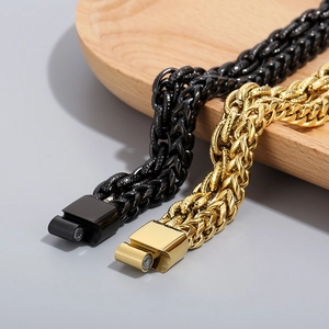 Detail of gold and black double layer Cuban link chains with magnetic buckles on wood