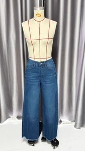 Détail d'un jean taille haute à jambe large avec délavage et ourlet effiloché