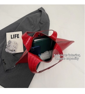 Interior view of large red croc-embossed tote bag showing tablet, phone, and umbrella