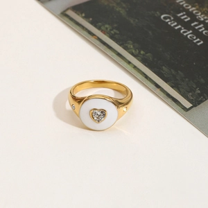 Close-up of heart-shaped white enamel ring with center zircon in 18K gold-plated steel