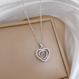 Detail of silver heart necklace with light blue stone and pave diamonds on silk