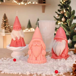 Detail of Santa Claus silicone mold and pink scented candle in festive snow setting