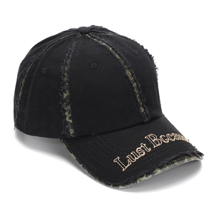 Détail de la casquette de baseball noire usée avec franges camouflage et broderie dorée