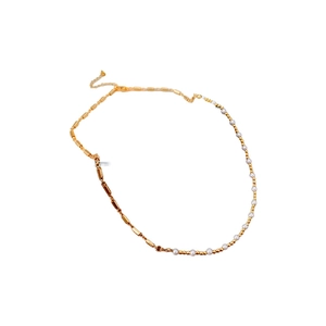 Minimalist gold beaded necklace with pearls and heart charm on a white background