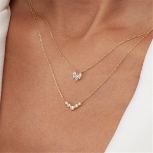Close-up of a double-layer 925 sterling silver gold necklace with white zircon pendants