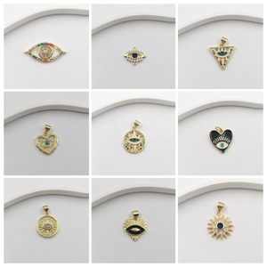 Collection of nine gold-plated evil eye pendants with sparkling zircons and enamel
