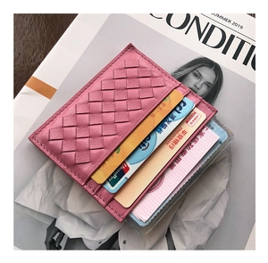 Pink woven sheepskin card holder with multiple slots on a summer fashion magazine