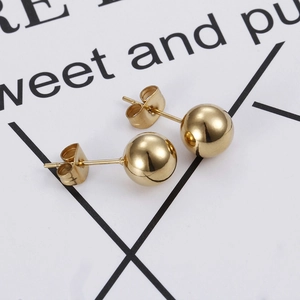 Minimalist gold ball stud earrings in polished titanium steel from a 45-degree angle view