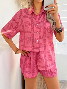 Detail of pink bohemian set featuring red Greek key and sun prints on shirt and shorts