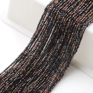 Macro detail of 2mm faceted black glass beads with iridescent metallic luster for DIY jewelry