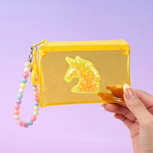 Macro detail of yellow unicorn coin purse with glitter sequins and colorful bead handle