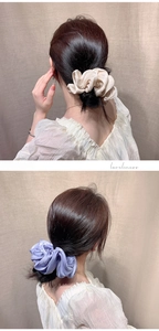 Detail of glossy pleated oversized hair scrunchies in beige and light purple on a bun