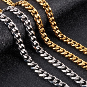 Close-up of gold and silver Cuban link necklaces on a textured black background