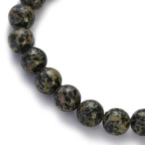 Macro view of polished green and black beaded natural stone bracelet with smooth textures