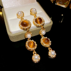Macro detail of vintage tassel earrings with tiger eye stone and pearls on jewelry box
