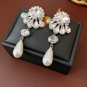Detail of silver floral earrings with crystal fan top and large pendant pearl drop