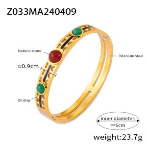 Detail view of gold titanium steel bangle with hollow design and inlaid natural gemstones