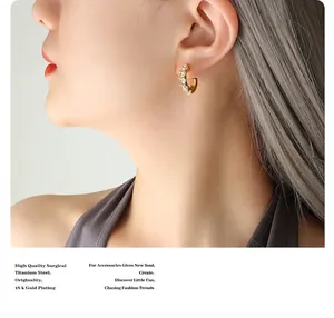 Détail des boucles d'oreilles en C en acier titane plaqué or 18K avec zircons blancs