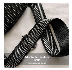 Detail of adjustable black and white herringbone woven strap with gunmetal metal buckle