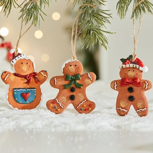 Three assorted resin gingerbread man ornaments with jute ropes on Christmas tree