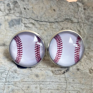 Gros plan de boucles d'oreilles en verre motif baseball sur une pierre naturelle