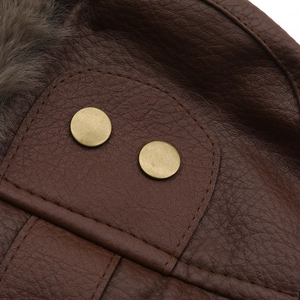 Detailed macro view of dark brown leather texture with plush fur lining and gold buttons
