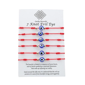 Dettaglio del set di 6 braccialetti rossi a 7 nodi con perline blu contro il malocchio
