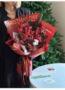 Detailed Christmas bouquet with red berries and roses in gold-stamped festive wrapping