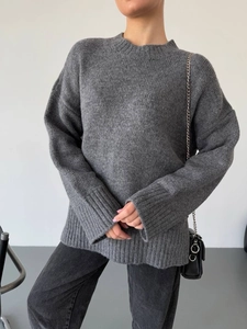 Detailed close-up of dark grey chunky knit sweater texture and relaxed oversize fit