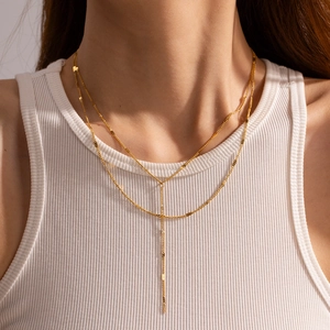 Close-up of a luxury gold double-layered Y-shaped stainless steel chain on a model