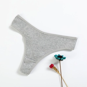 Grey ribbed cotton thong for women, flat lay view on white background with dried flower