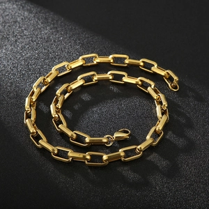 Detail view of gold square link chain necklace with lobster clasp on black background