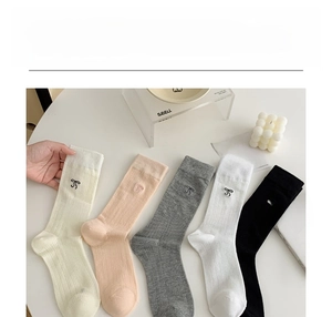 Détail de chaussettes en résille respirante avec nœud et broderie JS en cinq couleurs