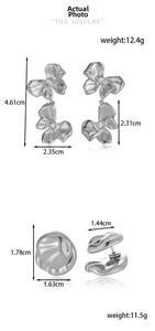 Macro view of silver floral earrings and irregular lava studs with measurements