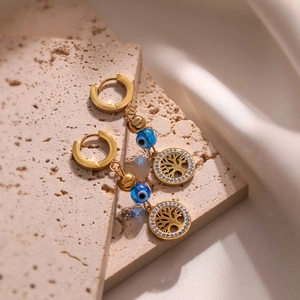 Gold plated tree of life earrings with blue evil eye beads on a natural beige stone