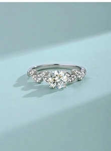 Macro shot of Moissanite ring with leaf-shaped band and sparkling round center stone