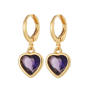 Détail de boucles d'oreilles cœur en or avec pierres violettes et fermoir à charnière