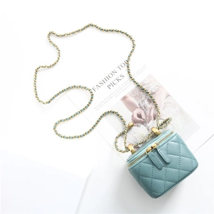 Top view of light blue quilted vanity case bag with gold chain strap and top handle