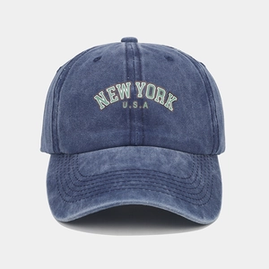 Detailed close-up of dark blue washed denim baseball cap with New York USA embroidery