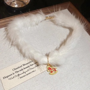 Detail of white plush collar with golden red rocking horse pendant and Chinese engraving