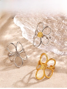 Detailansicht der hohlen Blumenringe in Gold und Silber auf Steinoberfläche