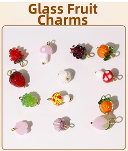 Macro detail of colorful glass fruit pendants like strawberry and persimmon for DIY jewelry