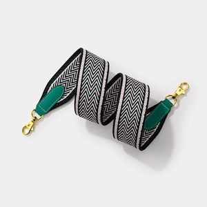 Wide woven shoulder strap with green herringbone pattern and leather ends for crossbody bags
