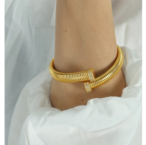Detail of gold tubogas cuff bracelet with sparkling crystal ends worn on a wrist