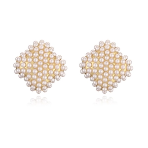 Macro shot of gold-plated rhombus stud earrings set with small white pearls