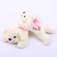 Detail of white plush teddy bears with I love you embroidery and pink ribbons