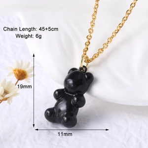 Macro shot of 19mm black gummy bear pendant necklace with 45cm gold chain on marble
